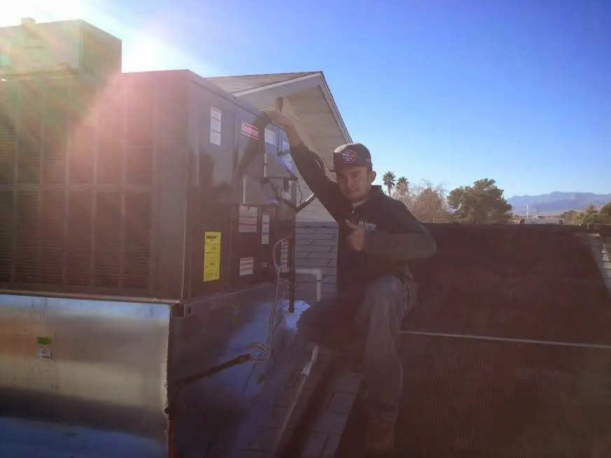 HVAC technician performing Heat Pump Repair on a rooftop unit in Smithfield